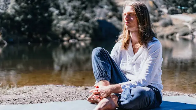 Harjeet, SGP Yoga Founder & Kundalini Yoga teacher sitting in a contemplative posture in front of a lake in Hidalgo, Mexico